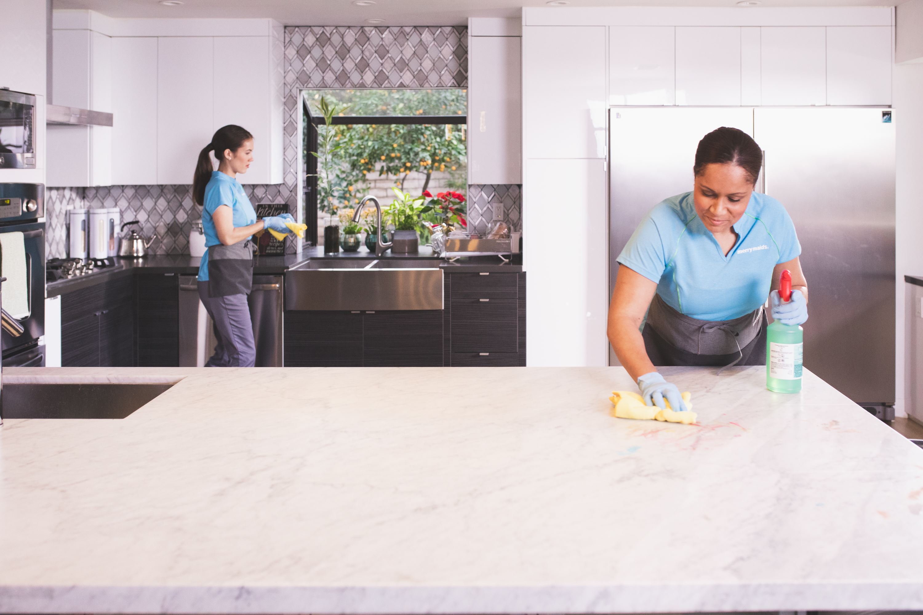 Merry Maids experts wiping down a kitchen during moving in cleaning