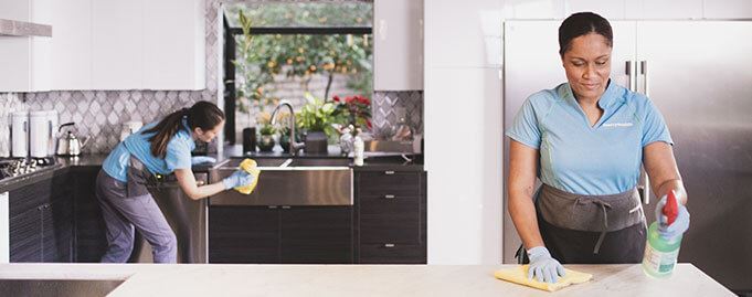 maids wiping down kitchen sink and counter